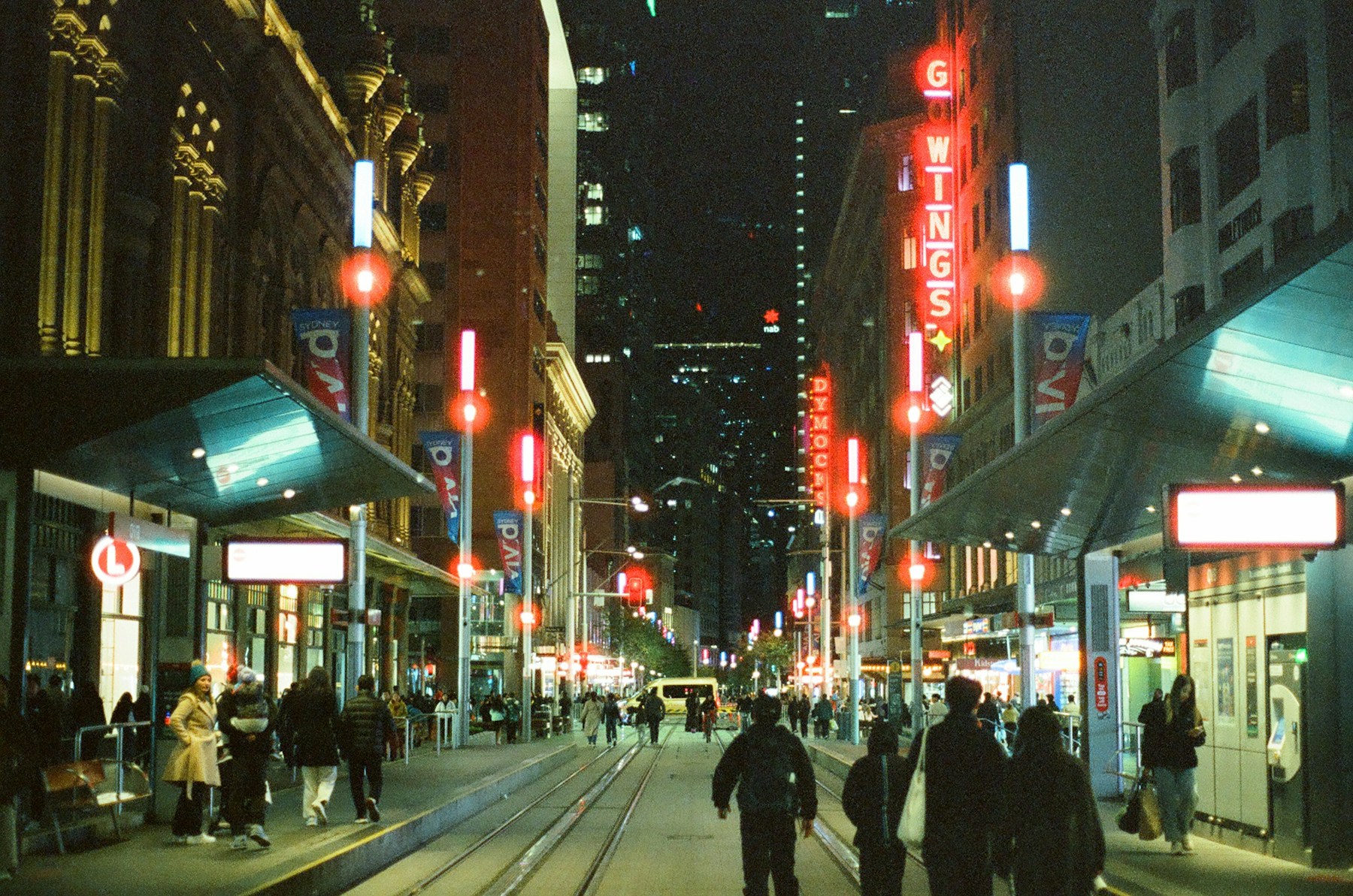 People and neon lights on a Sydney street at night