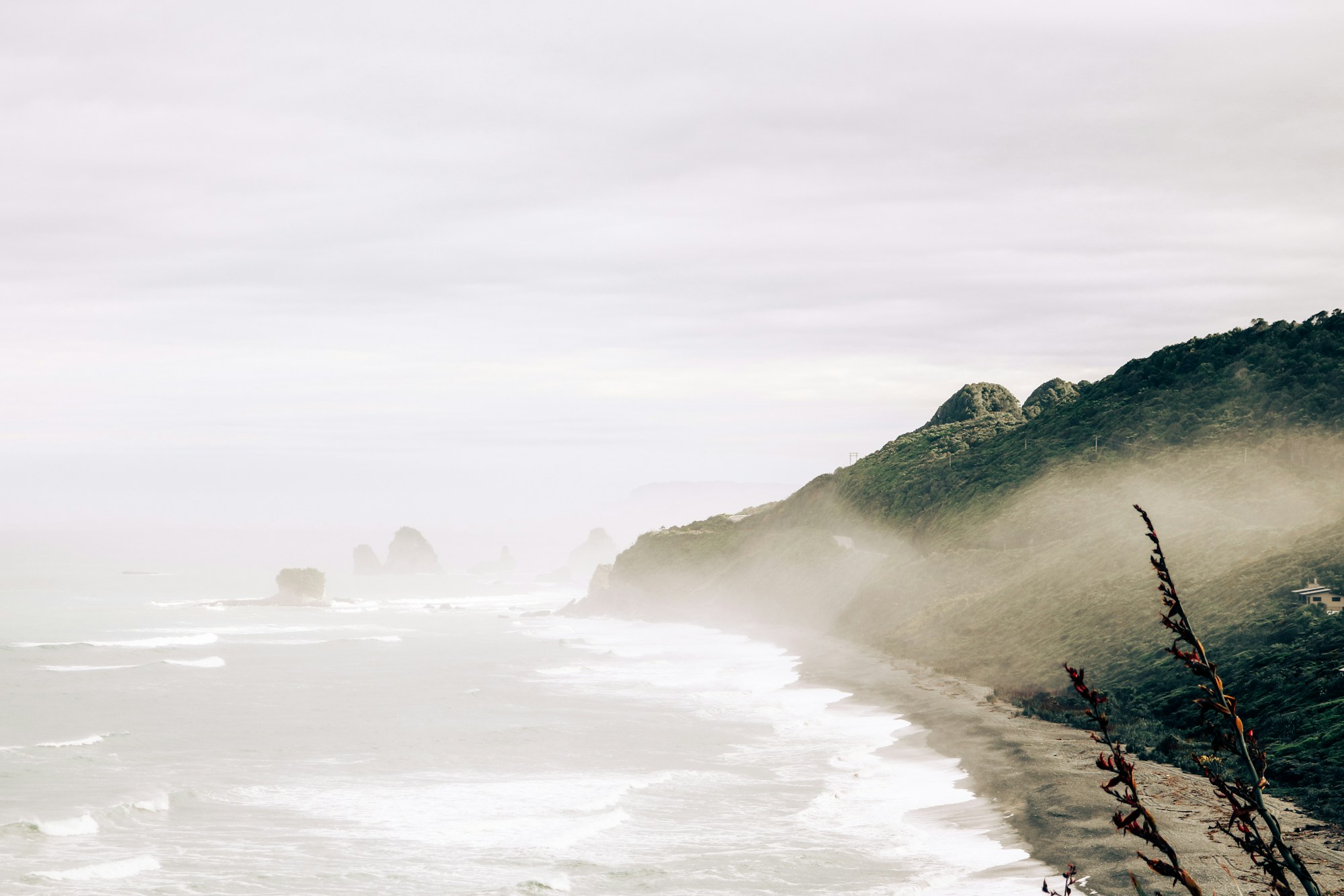 Misty coastal headlands above a quiet sea
